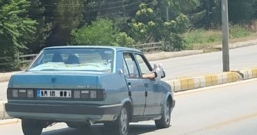 Ayaklarını camdan dışarı çıkaran yolcu trafiği riske attı