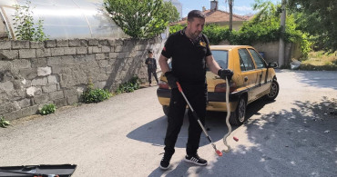 Park halindeki otomobilin altına giren yılan itfaiye ekiplerince kurtarıldı