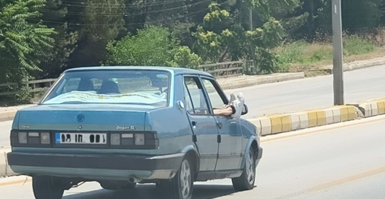 Ayaklarını camdan dışarı çıkaran yolcu trafiği riske attı
