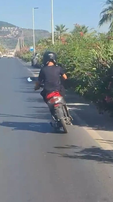 ANTALYA'NIN ALANYA İLÇESİNDE HAREKET HALİNDEKİ ELEKTRİKLİ MOTOSİKLETİN ÜZERİNE AYAĞA KALKARAK...