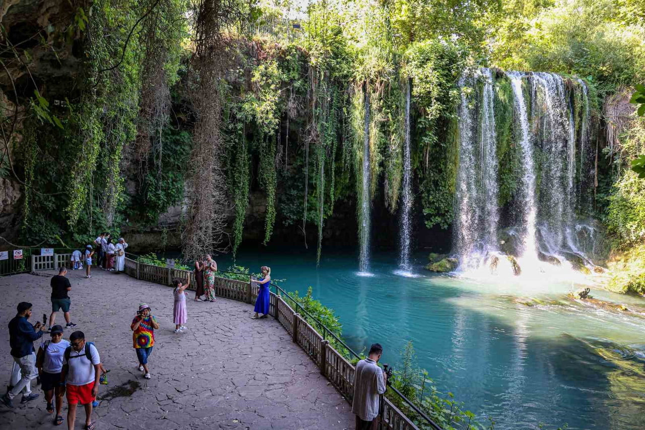 ANTALYA’NIN SİMGE DOĞAL GÜZELLİKLERİNDEN OLAN DÜDEN ŞELALESİ, HAVALARIN ISINMASIYLA YERLİ VE...
