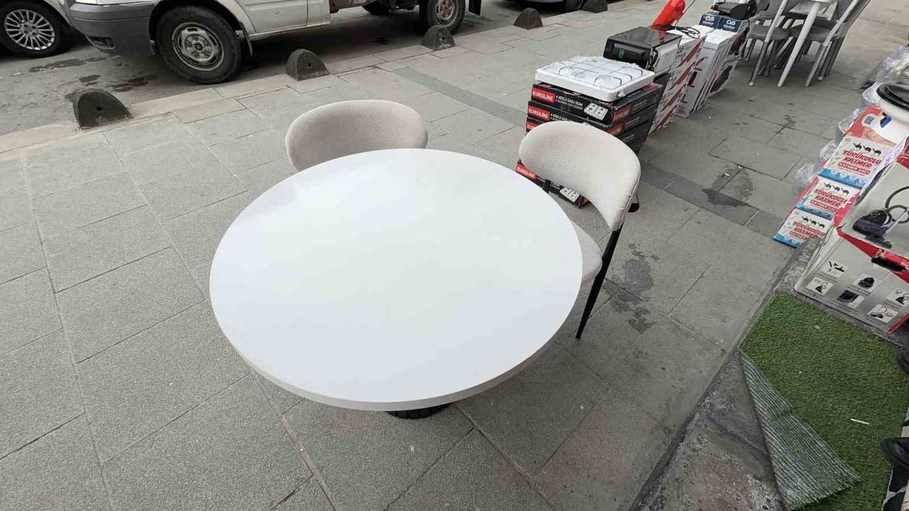 ARNAVUTKÖY İLÇESİNDE BİR MOBİLYA MAĞAZASI ÖNÜNDE SERGİLENEN MASA VE SANDALYE TAKIMINDAKİ İKİ...