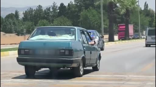 Ayaklarını camdan dışarı çıkartan yolcu trafiği riske attı