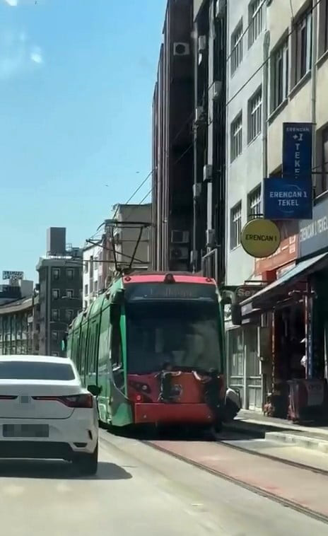 BURSA'DA SEYİR HALİNDEKİ TRAMVAYIN ARKASINA TUTUNARAK YOLCULUK YAPAN İKİ ÇOCUK, CEP TELEFONU...