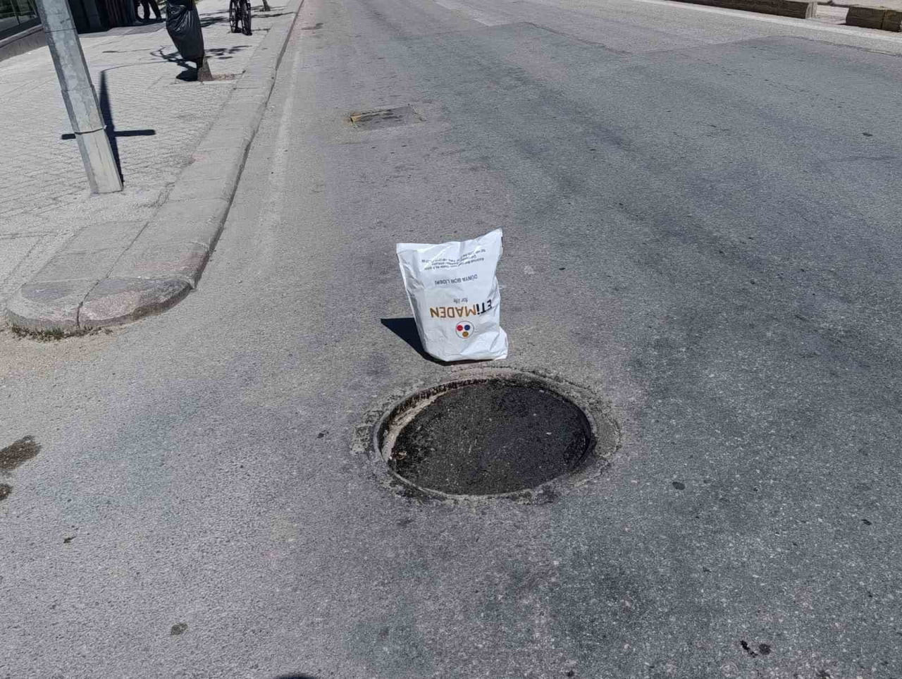 ESKİŞEHİR'DE BİR VATANDAŞIN ÇÖKEN VE TEHLİKE ARZ EDEN RÖGAR KAPAĞININ FARK EDİLMESİ İÇİN YANINA...