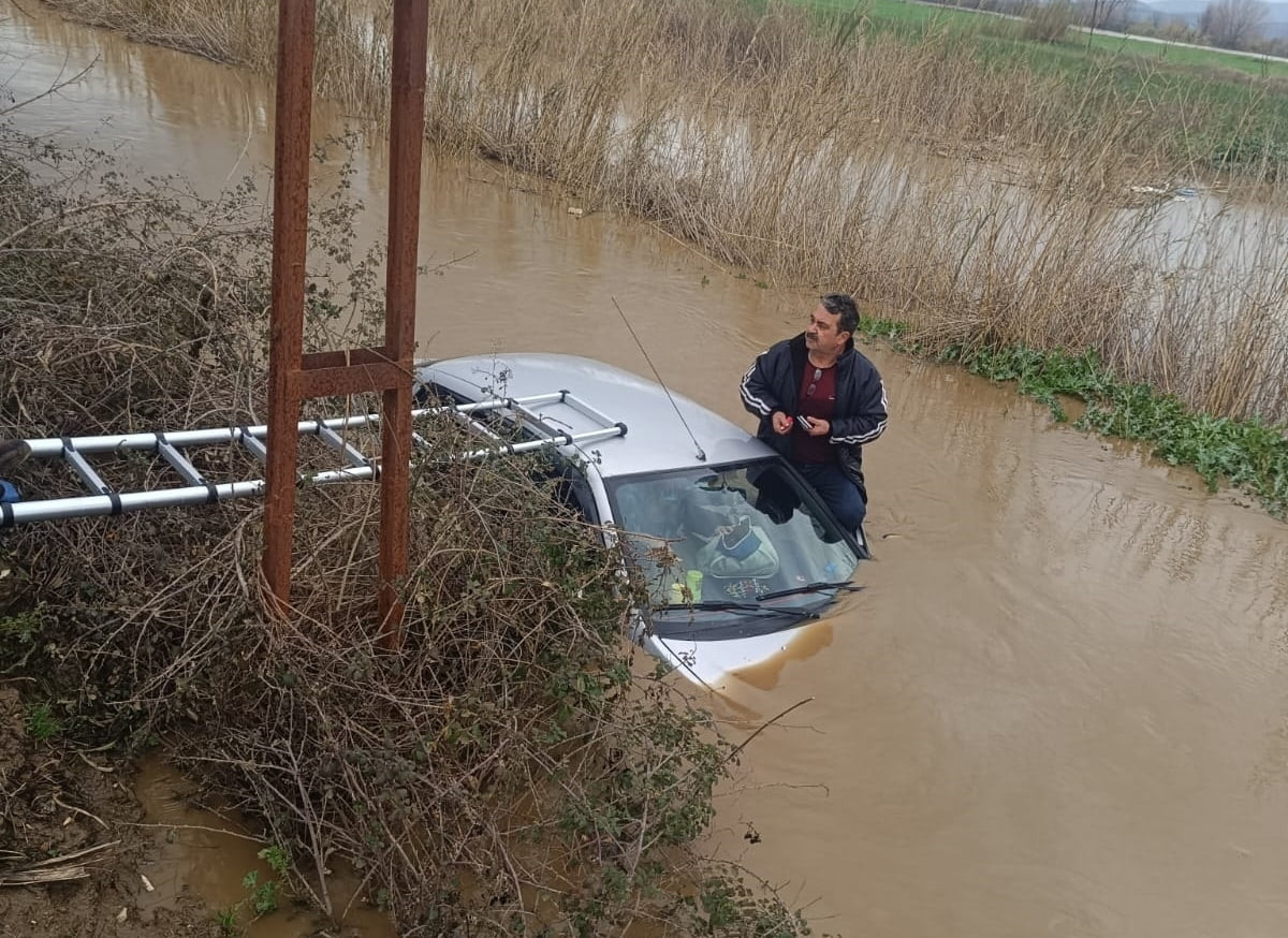 İzmir'in Bayındır ilçesinde sağanak sonrası biriken suda otomobiliyle mahsur kalan sürücü Deniz...