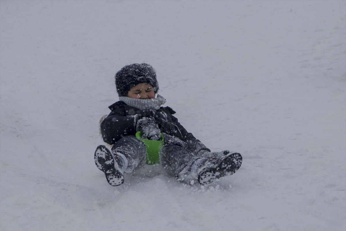 Kars'ta etkili olan kar yağışıyla kent merkezi beyaza bürünürken, çocuklar da kızak keyfi...