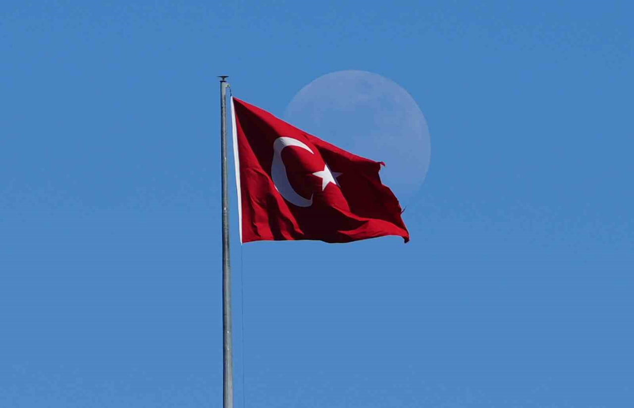 KIRIKKALE'DE GÜN İÇİNDE BELİREN ŞİŞKİN AY, MAVİ GÖKYÜZÜNDE DALGALANAN TÜRK BAYRAĞIYLA AYNI KAREDE...