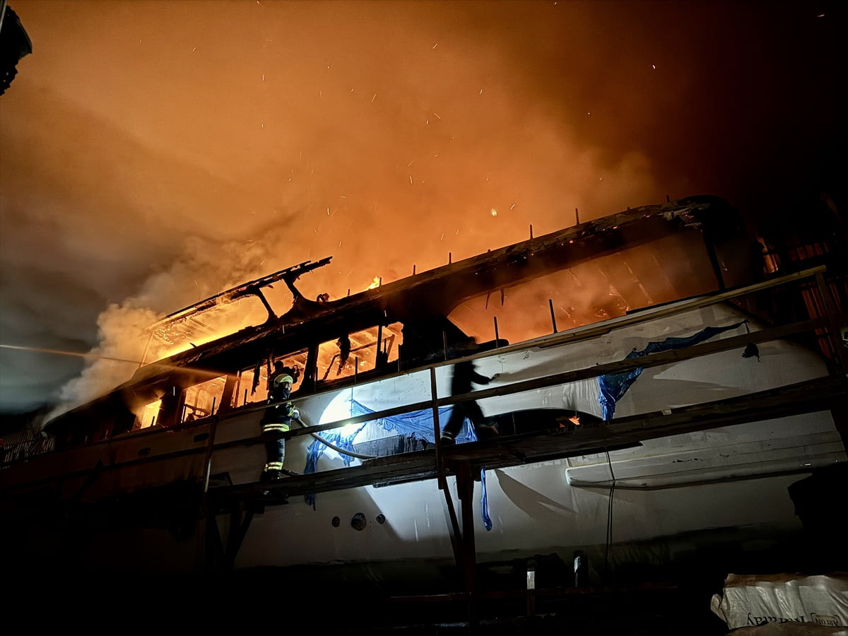 Muğla'nın Fethiye ilçesinde tersanedeki teknede çıkan yangın söndürülmeye çalışılıyor.