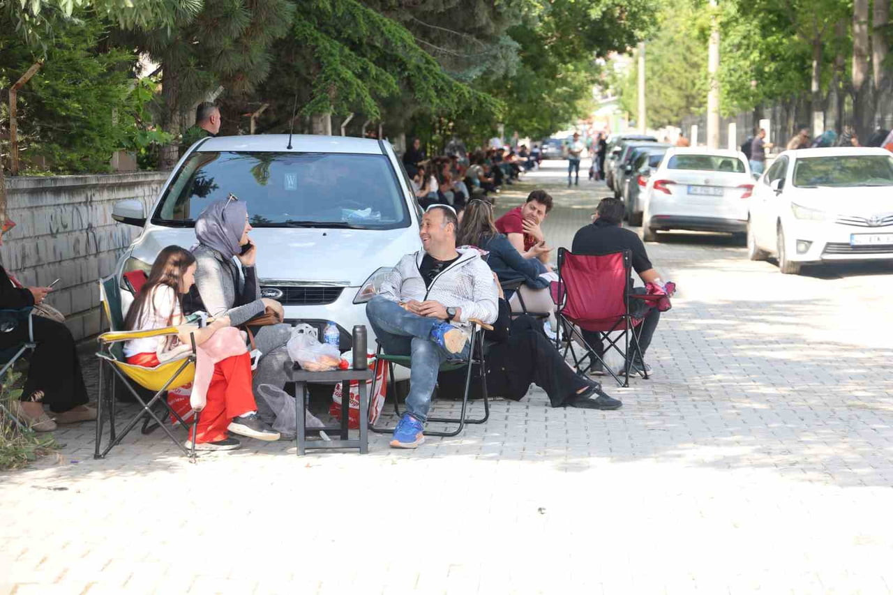 ÖĞRENCİLER SINAVDA TER DÖKERKEN, VELİLER İSE KAMP SANDALYELERİ İLE SOKAKLARI DOLDURDU.