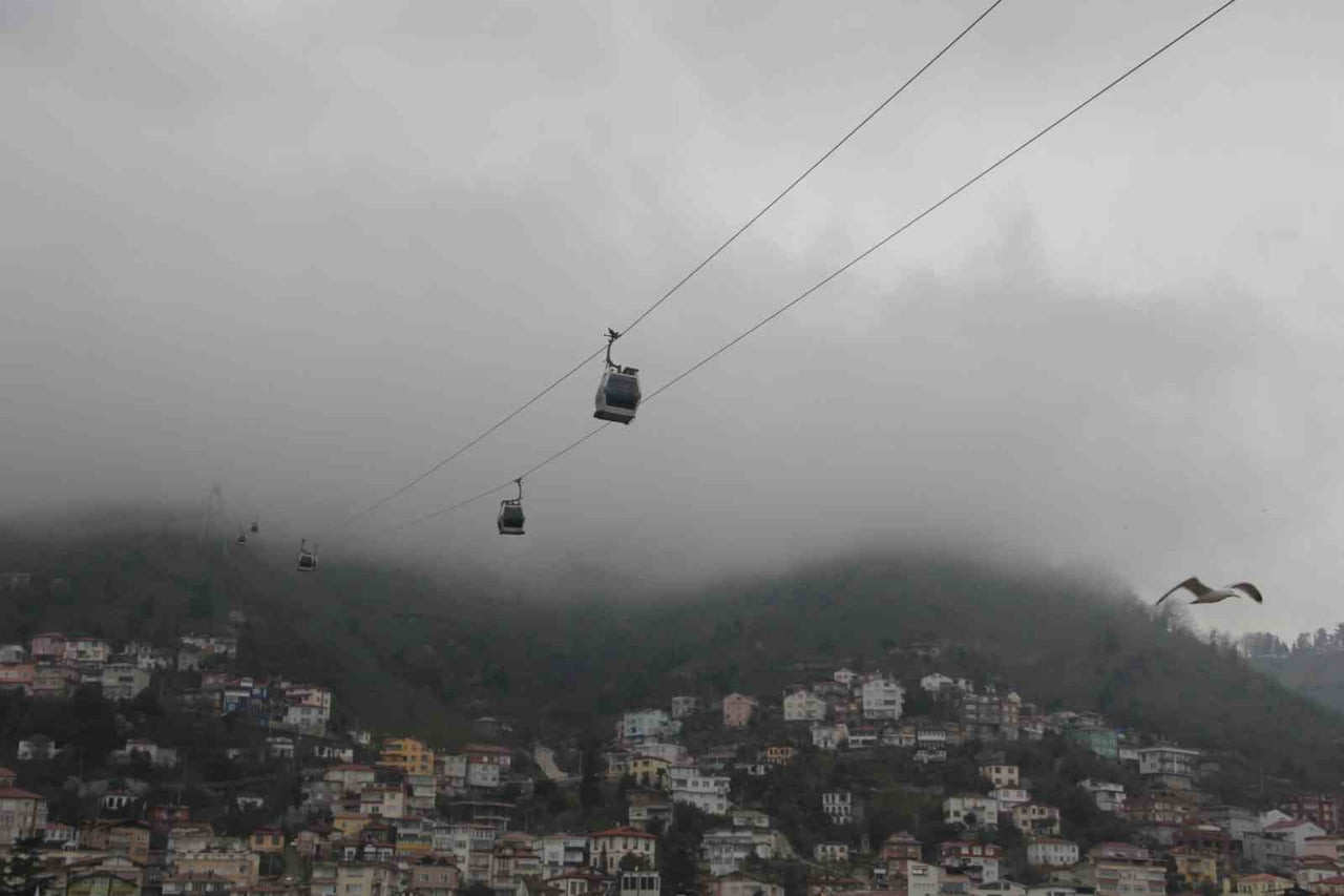 TELEFERİK KABİNLERİ VE KUŞLAR SİSLE BİRLİKTE GÖRSEL GÜZELLİK SUNDU.