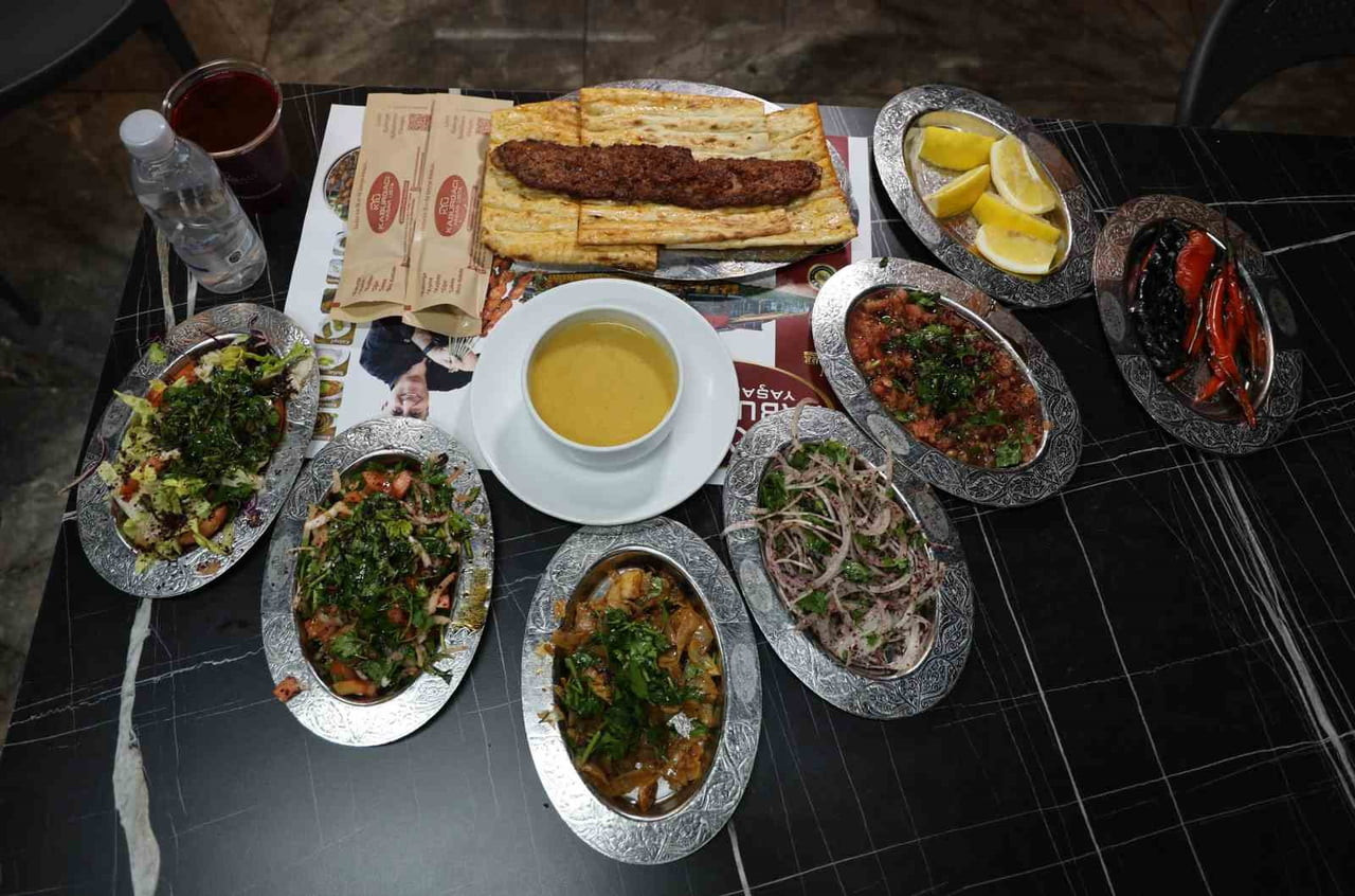 TESCİLLİ ADANA KEBABI VE YANINDA SERVİS EDİLEN BOL YEŞİLLİKLİ SALATALAR, VÜCUDUN EN GÜÇLÜ...